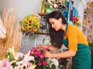 Floral shop owner arranges flowers in her shop