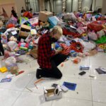 A person sorting through a pile of toys on the floor.