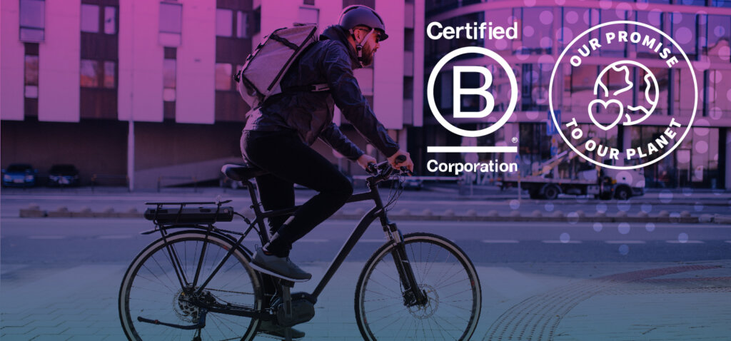 A person riding their bike, with the B Corp and Promise To Our Planet logos.