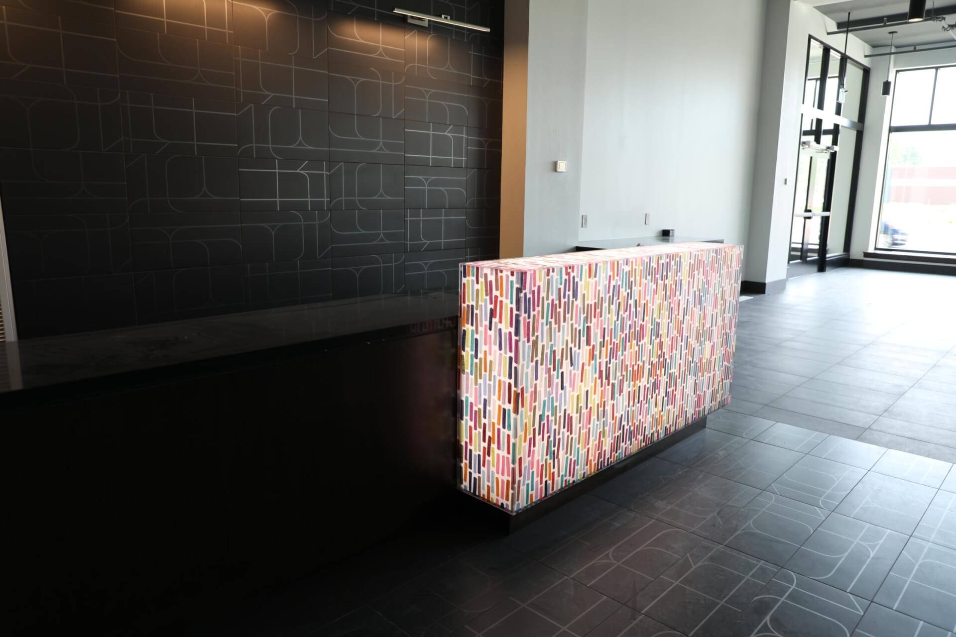 A colorful desk sitting in an open lobby.