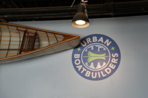  A logo for Urban Boatbuilders and part of a boat.