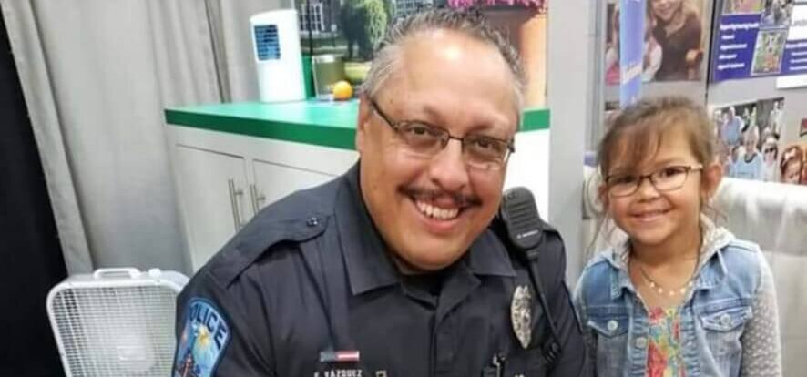 A police officer and a child smiling for a photo