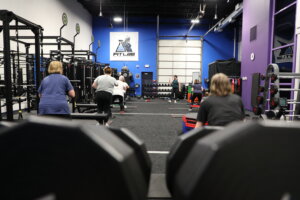 A fitness studio where people are taking a class.