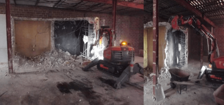 A robotic concrete cutting machine inside of a partially demolished building.