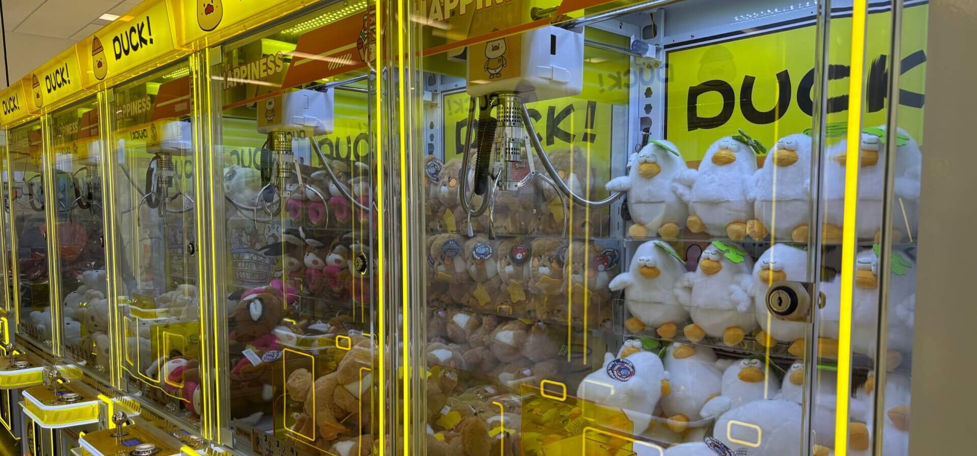 A row of claw machines in an arcade.