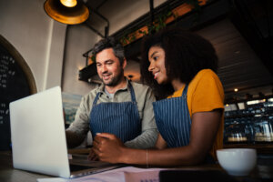 Two employees looking at a computer screen.
