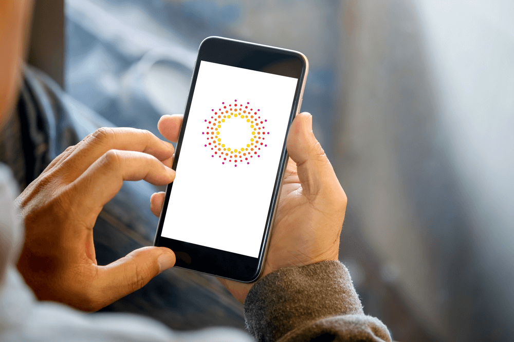 person holding a phone with a Sunrise Banks logo on screen