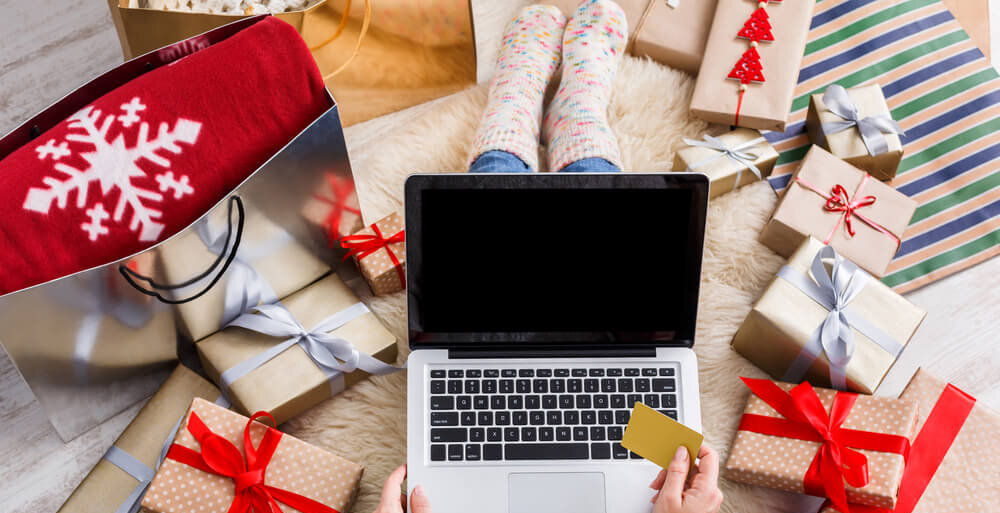 a person holding a credit card with a laptop