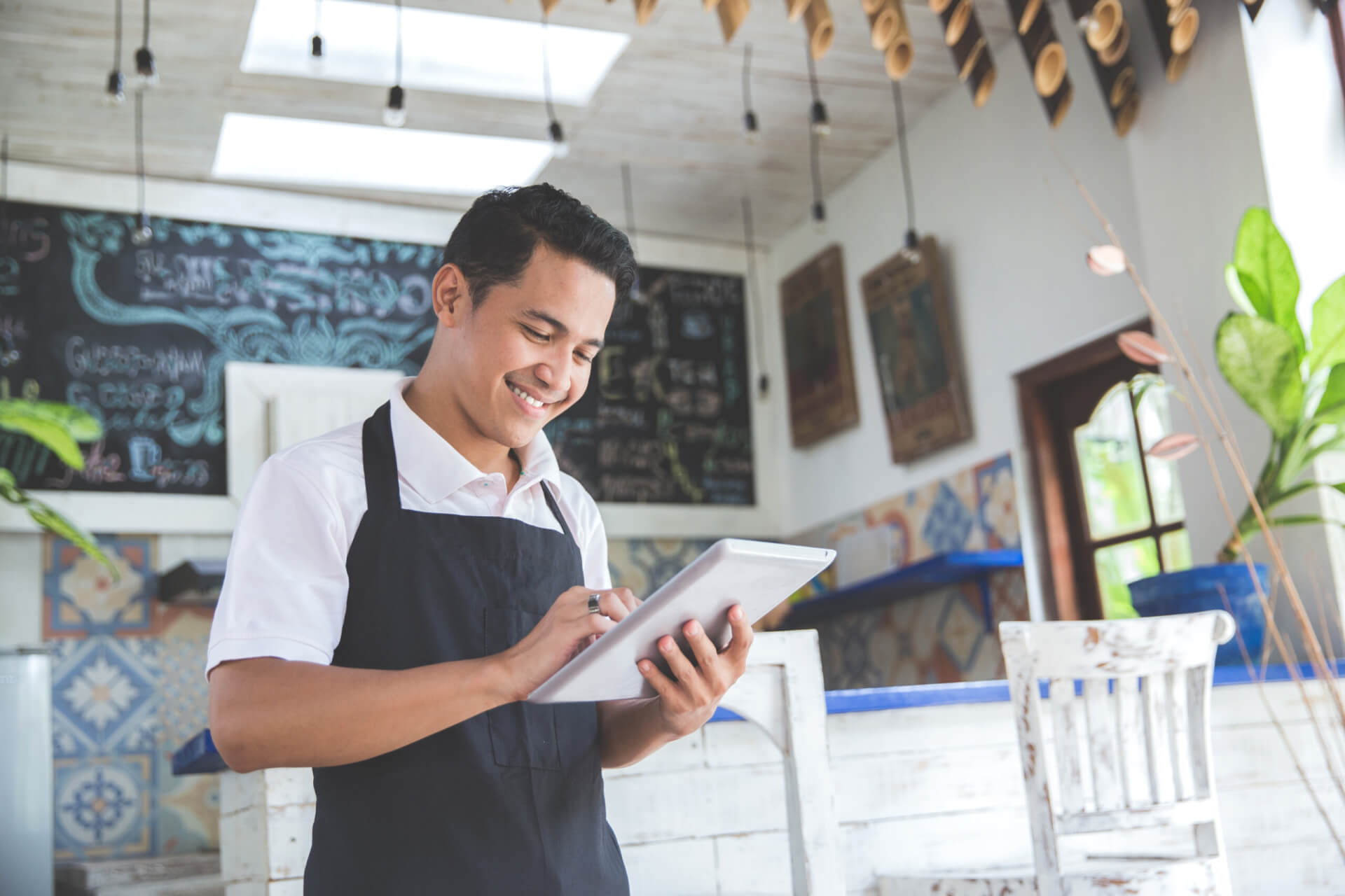 A young Hispanic small business owner conducts business on a tablet