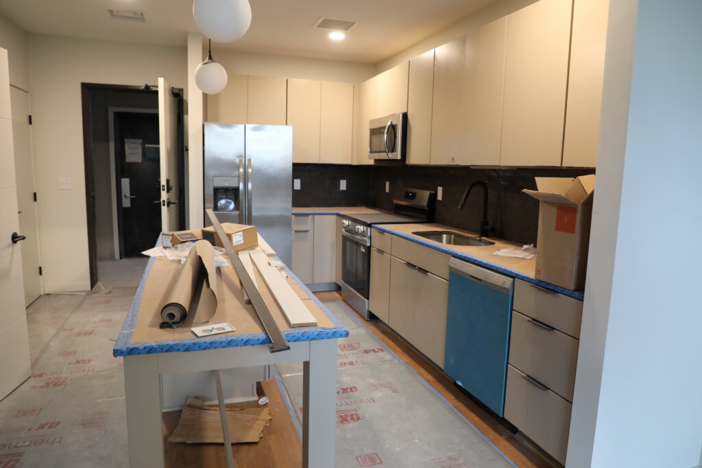 A kitchen under construction inside a one-bedroom apartment.