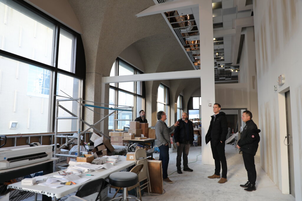 A group of people standing inside a building under construction.
