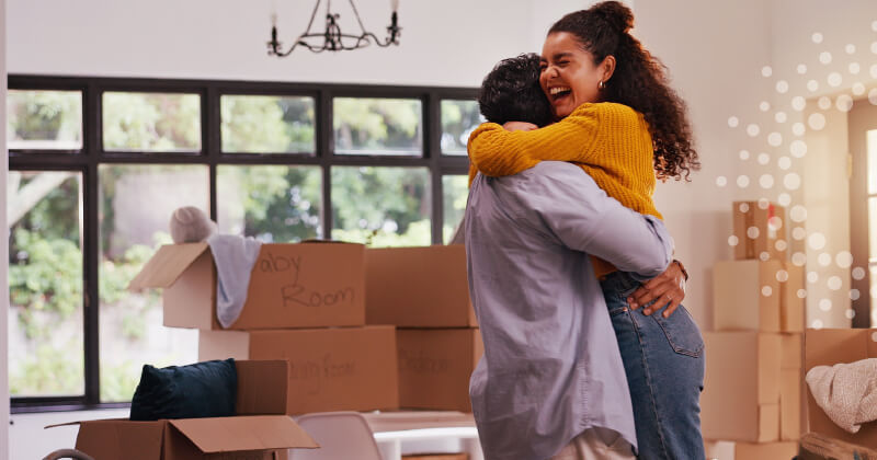 A couple hugging after moving into a house together.