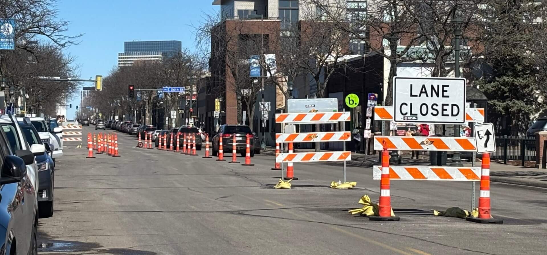 A city street with "Road Closed" signs blocking one side.