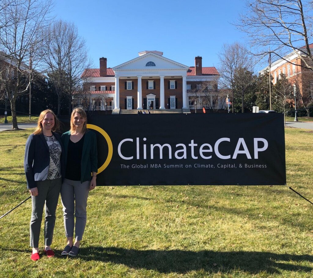 Two women standing in front of a banner that says ClimateCAP.