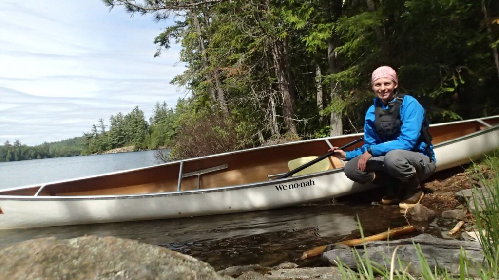 Laura Wildenborg posing in front of a canoe.