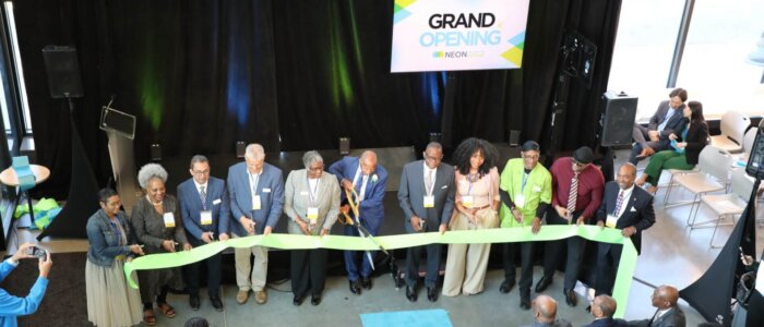 A group of NEON staff members cut the ribbon at the grand opening of NEON Collective Kitchens