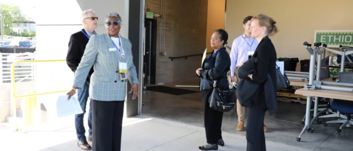 A NEON Staff member shows visitors a loading dock at the new Collective Kitchens building.
