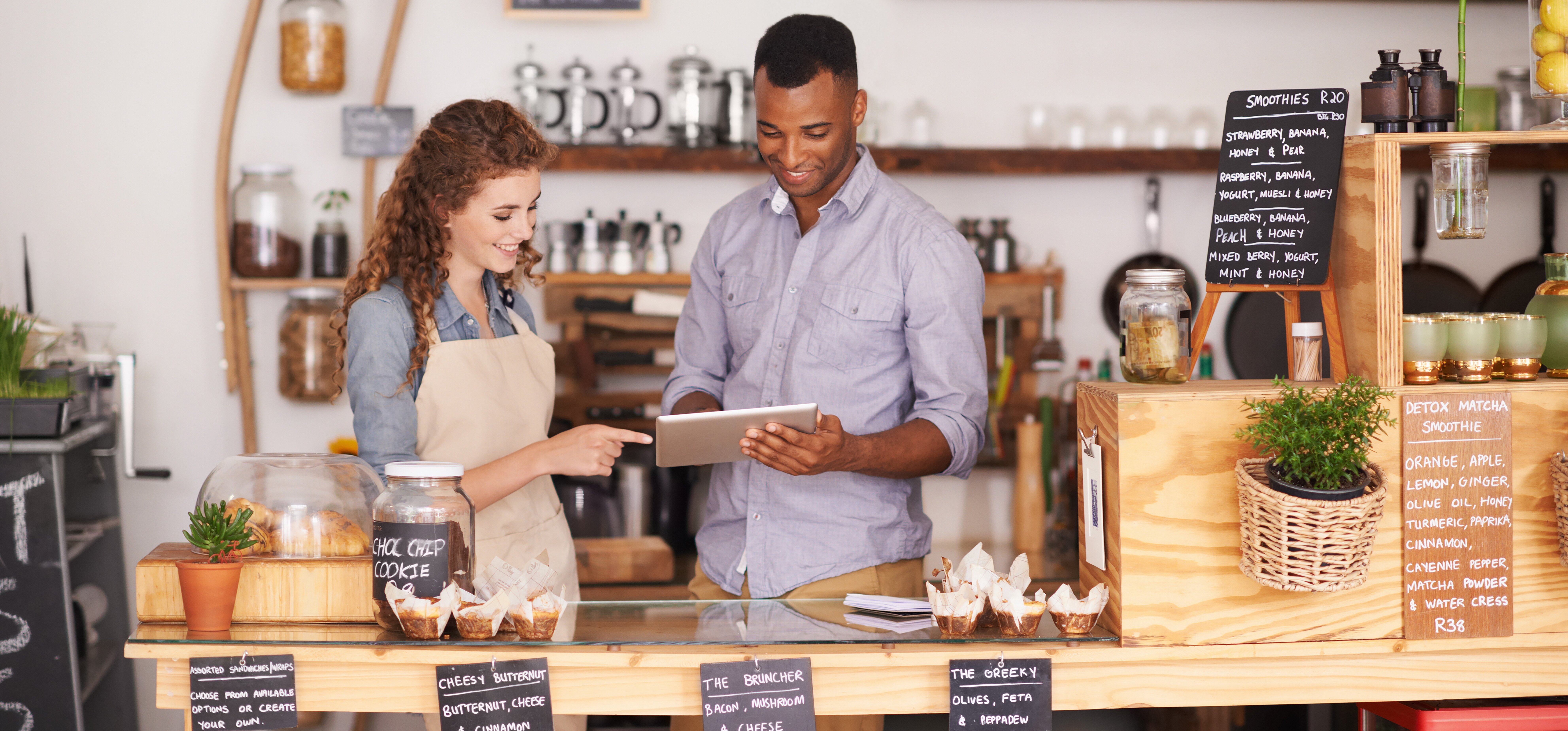 Two coffee shop owners working behind a counter.