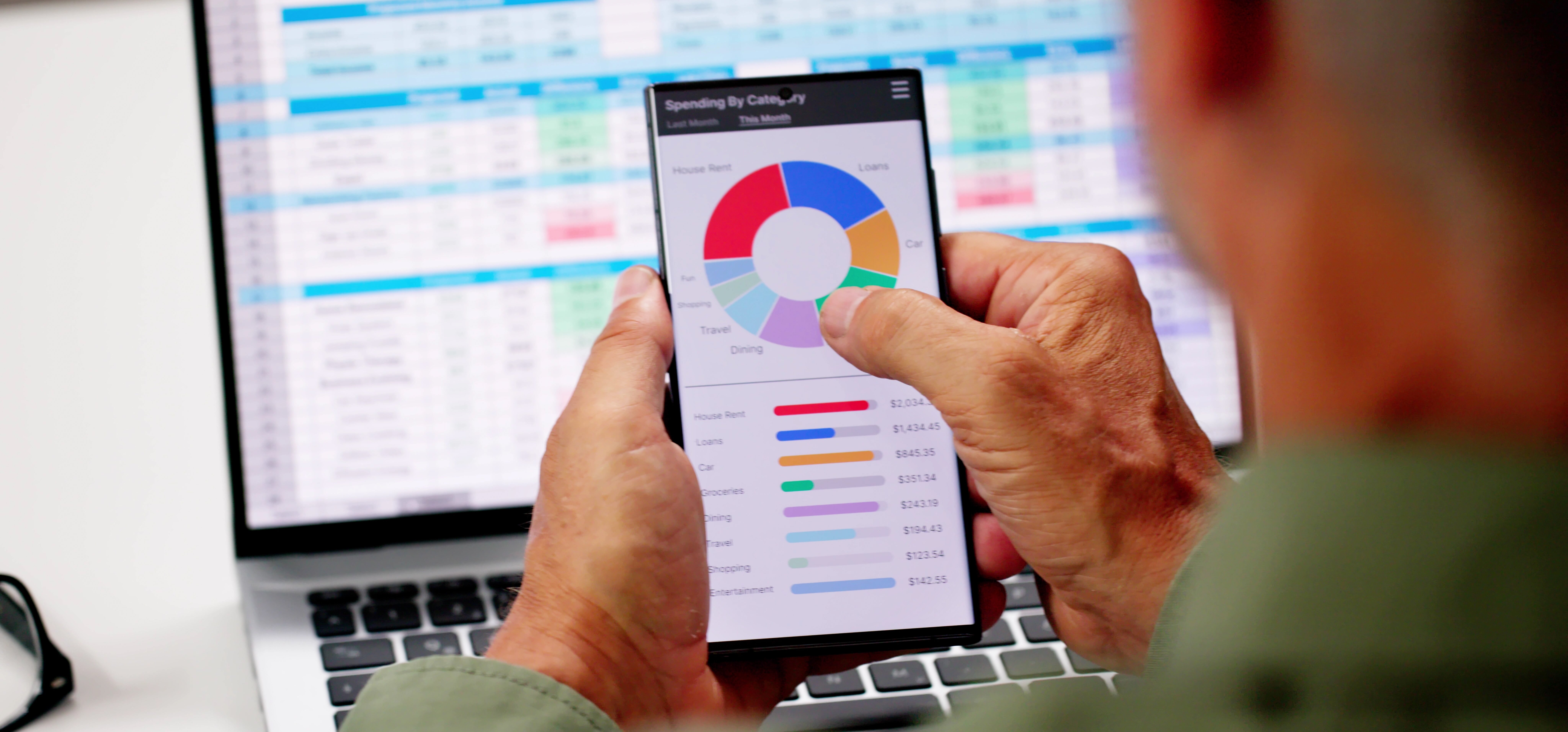 A man using a mobile phone app to review finances.