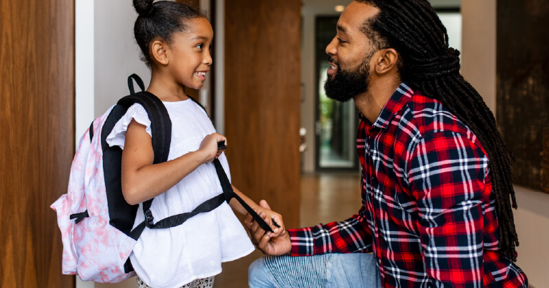 A father sends his young daughter off to school.
