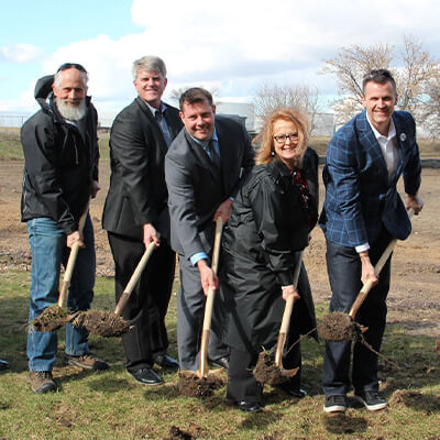 People holding shovels at a groundbreaking event.