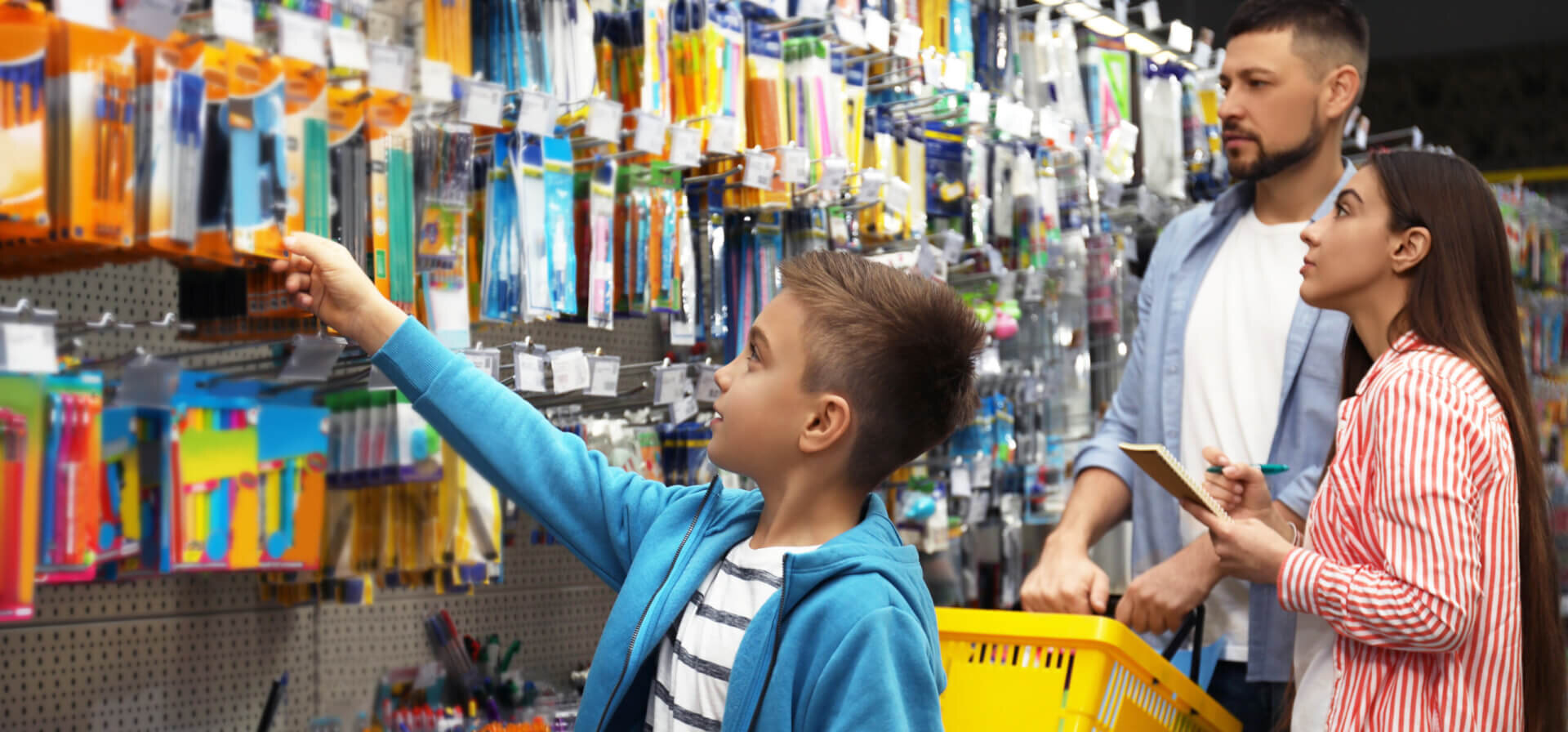 A young boy shopping for school supplies with his family.